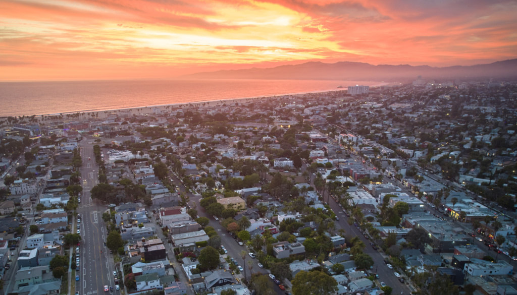 An overhead aerial shot of Venice, CA toward the Pacific Ocean at sunset
